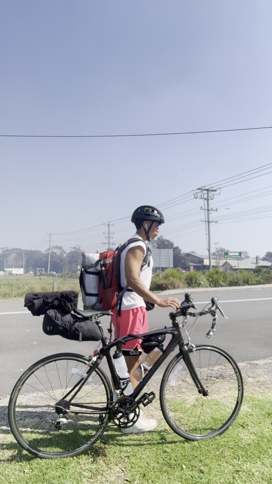 Lumore by the highway with his loaded road bike